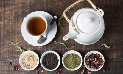 herbal-tea-cup-teapot-with-bowls-tea-herbs-wooden-desk